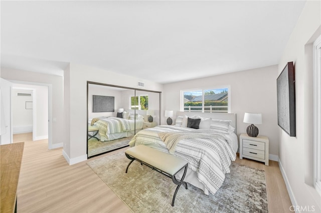 bedroom with light wood-type flooring and baseboards
