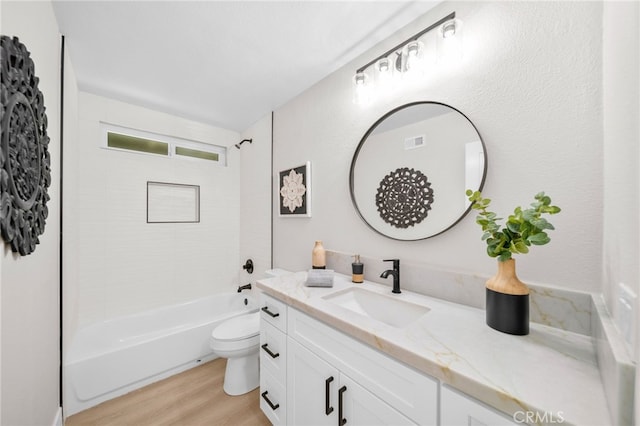 bathroom featuring wood finished floors, vanity, toilet, and washtub / shower combination