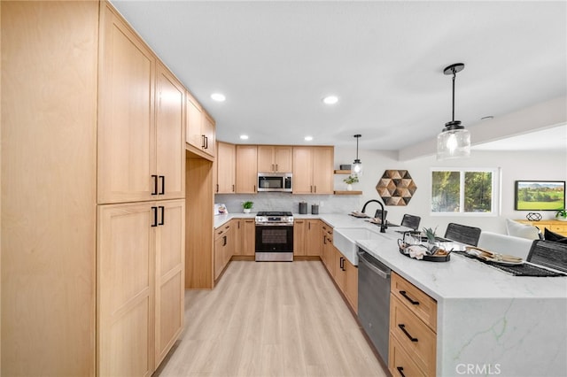 29140 Via Norte, Temecula, CA 92591 - kitchen with appliances with stainless steel finishes, light brown cabinetry, a peninsula, light wood-style flooring, and light stone counters