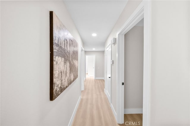 corridor featuring recessed lighting, light wood-type flooring, and baseboards