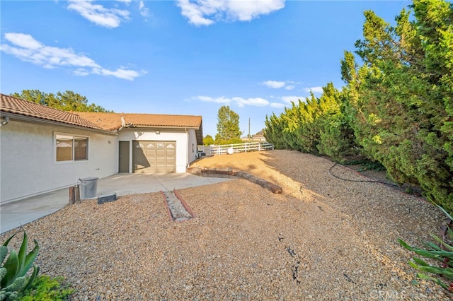 view of yard featuring an attached garage and fence