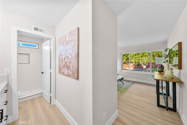 hall with light wood finished floors and baseboards