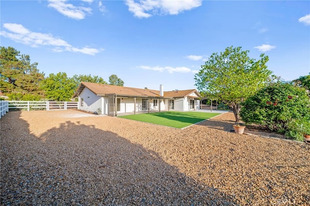 rear view of house with a fenced backyard and a patio area