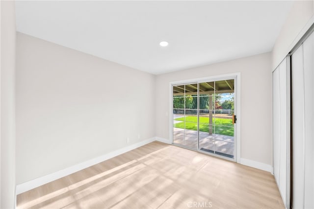 unfurnished bedroom with access to outside, baseboards, light wood finished floors, and recessed lighting
