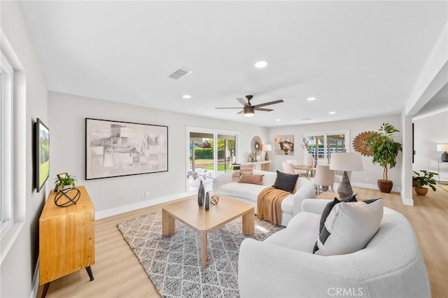 living area featuring light wood-type flooring, ceiling fan, baseboards, and recessed lighting
