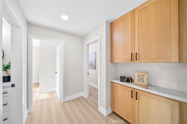 hall with light wood-style flooring, baseboards, and recessed lighting