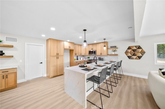 29140 Via Norte, Temecula, CA 92591 - kitchen with open shelves, appliances with stainless steel finishes, light wood finished floors, a breakfast bar, and recessed lighting