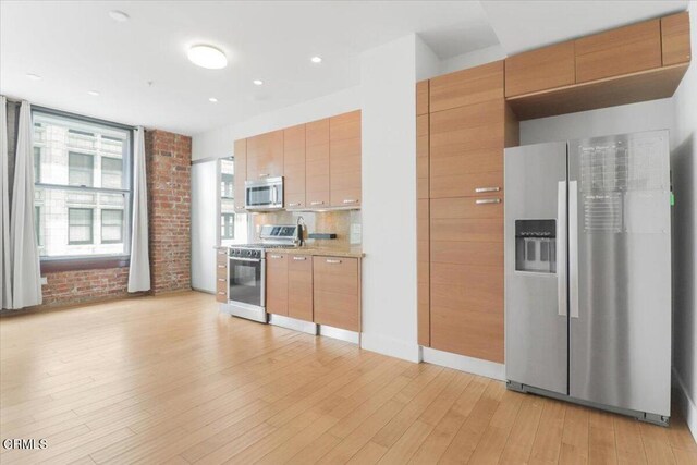 460 S Spring St Unit 713, Los Angeles, CA 90013 - kitchen with appliances with stainless steel finishes, light wood-type flooring, light countertops, decorative backsplash, and modern cabinets