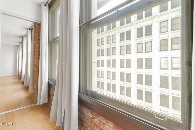460 S Spring St Unit 713, Los Angeles, CA 90013 - corridor with hardwood / wood-style flooring and brick wall