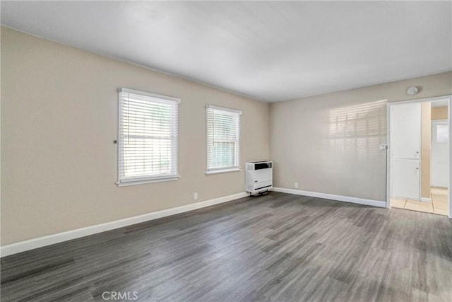 1922 Locust Ave, Long Beach, CA 90806 - spare room featuring heating unit, wood finished floors, baseboards, and a smoke detector