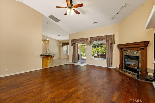 9539 Carmel Rd, Atascadero, CA 93422 - unfurnished living room featuring track lighting, wood finished floors, a fireplace, ceiling fan, and high vaulted ceiling