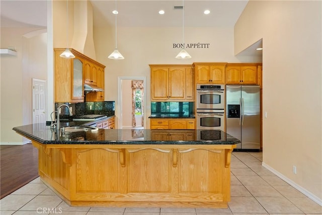9539 Carmel Rd, Atascadero, CA 93422 - kitchen with stainless steel appliances, a sink, a peninsula, a high ceiling, and decorative backsplash