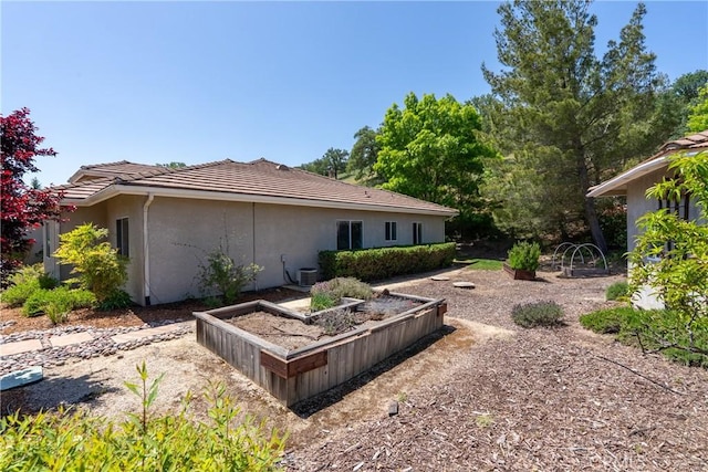 9539 Carmel Rd, Atascadero, CA 93422 - view of property exterior with a garden, stucco siding, and a tiled roof