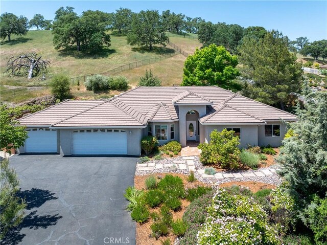 9539 Carmel Rd, Atascadero, CA 93422 - single story home with an attached garage, stucco siding, a tiled roof, and asphalt driveway