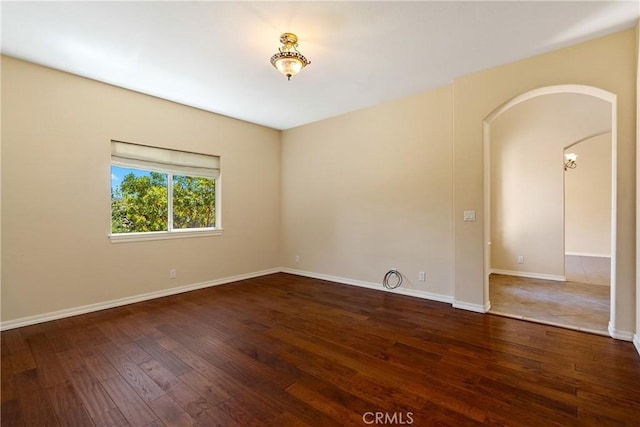 9539 Carmel Rd, Atascadero, CA 93422 - empty room featuring arched walkways, hardwood / wood-style floors, and baseboards