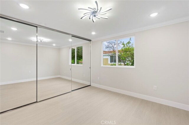 2202 Via Mariposa E Unit B, Laguna Woods, CA 92637 - unfurnished bedroom with crown molding, light wood-type flooring, baseboards, recessed lighting, and a closet