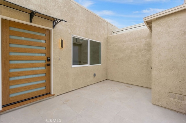 2202 Via Mariposa E Unit B, Laguna Woods, CA 92637 - entrance to property with a patio area and stucco siding