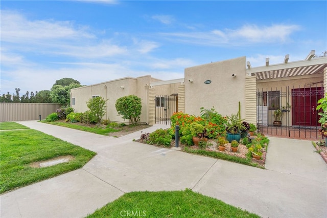 2202 Via Mariposa E Unit B, Laguna Woods, CA 92637 - view of front of property featuring a gate and stucco siding
