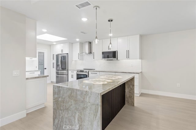 2202 Via Mariposa E Unit B, Laguna Woods, CA 92637 - kitchen featuring stainless steel appliances, wall chimney exhaust hood, backsplash, light stone counters, and baseboards