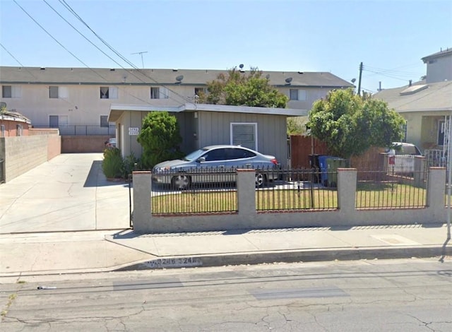 view of front of home with a fenced front yard and concrete driveway