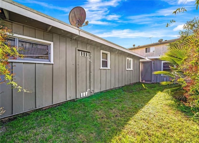 view of side of property featuring board and batten siding and a yard