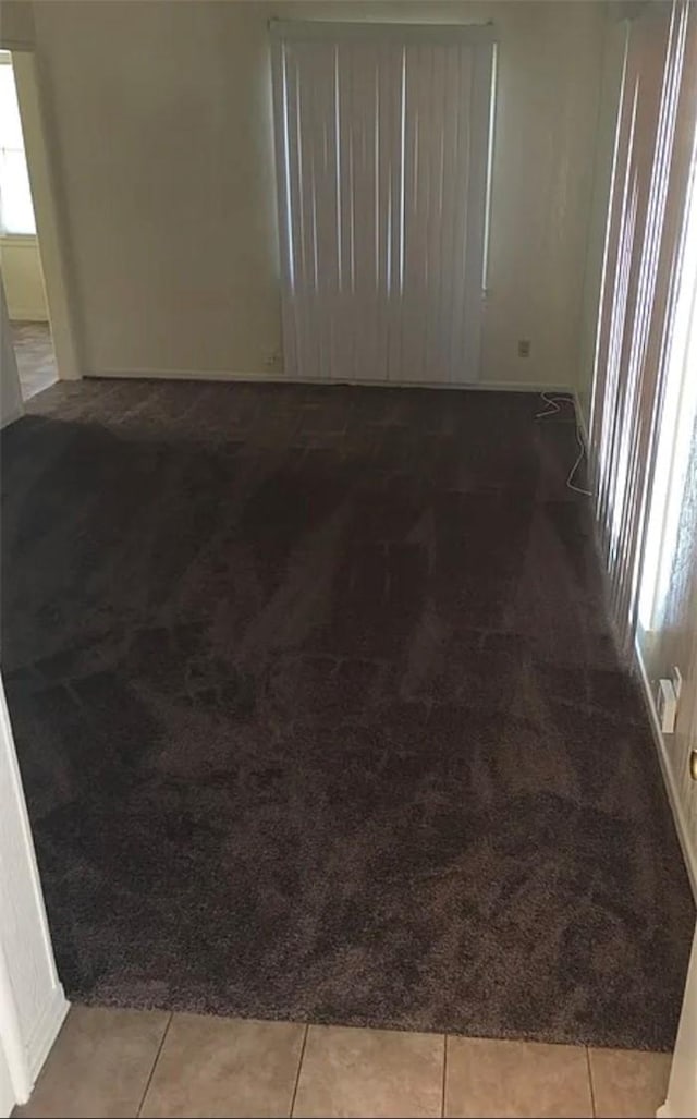 unfurnished room with carpet and baseboards
