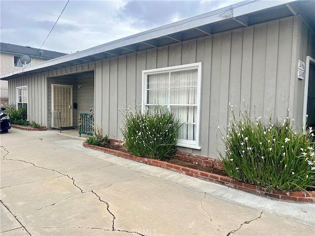 property entrance featuring board and batten siding and a patio