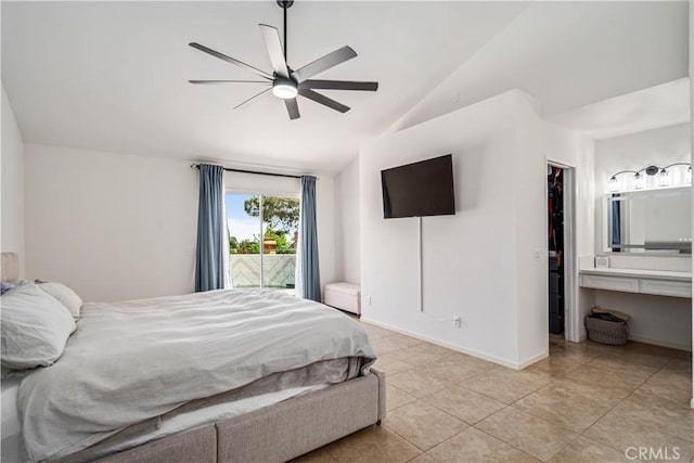 bedroom featuring lofted ceiling, light tile patterned flooring, a walk in closet, access to outside, and baseboards