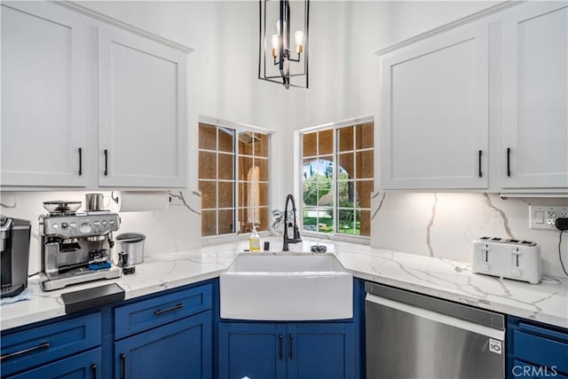 kitchen featuring stainless steel dishwasher, a sink, blue cabinetry, a chandelier, and white cabinets