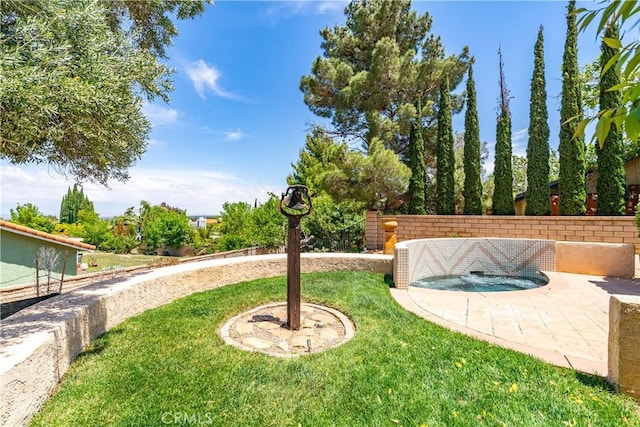 view of green lawn with an in-ground hot tub and a patio area