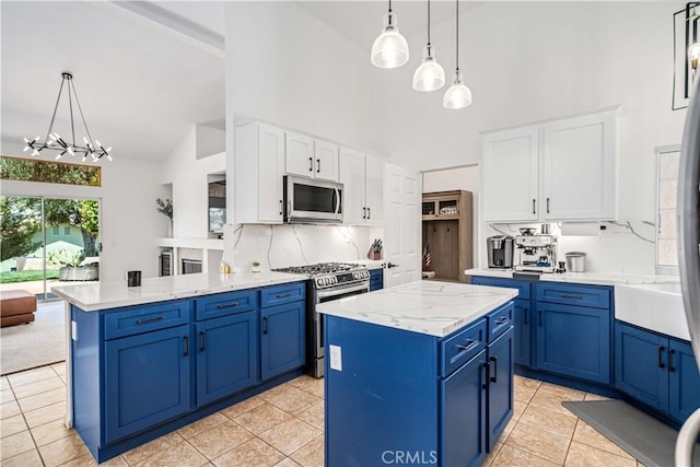 kitchen with stainless steel appliances, blue cabinets, high vaulted ceiling, white cabinets, and decorative backsplash