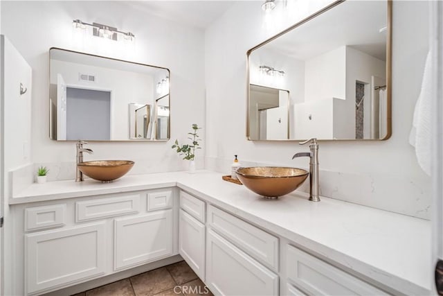 bathroom with tile patterned floors and double vanity