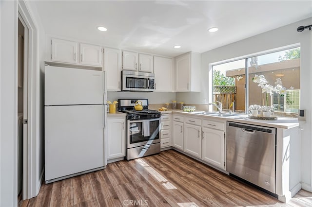762 Dragonfly Ct, San Jose, CA 95133 - kitchen with appliances with stainless steel finishes, white cabinets, wood finished floors, a sink, and recessed lighting