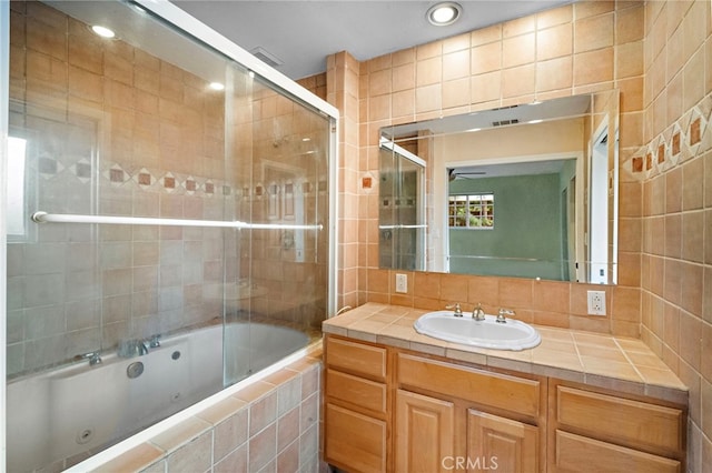 bathroom with ceiling fan, a combined bath / shower with jetted tub, vanity, and recessed lighting