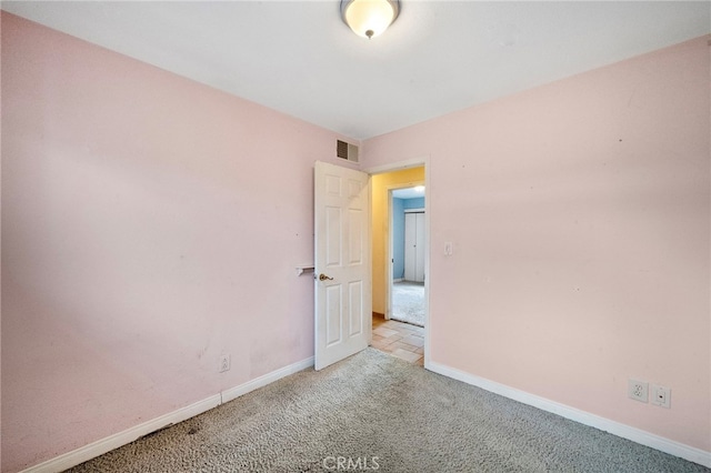 unfurnished room with carpet flooring and baseboards