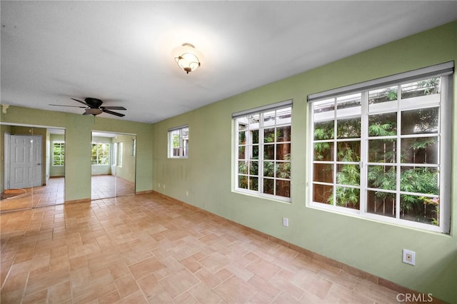 empty room featuring baseboards and a ceiling fan