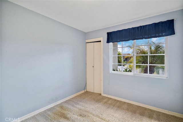 carpeted spare room with baseboards