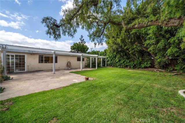 view of grassy yard with a patio area
