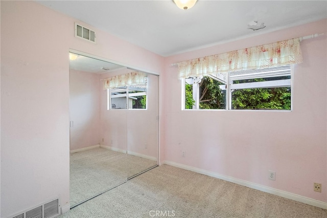 spare room featuring carpet flooring, plenty of natural light, and baseboards
