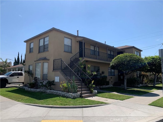 view of property featuring stucco siding and a front yard