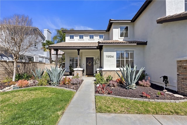 11934 Timber Mountain Ct, Rancho Cucamonga, CA 91739 - view of front facade with covered porch, stucco siding, a tile roof, fence, and brick siding
