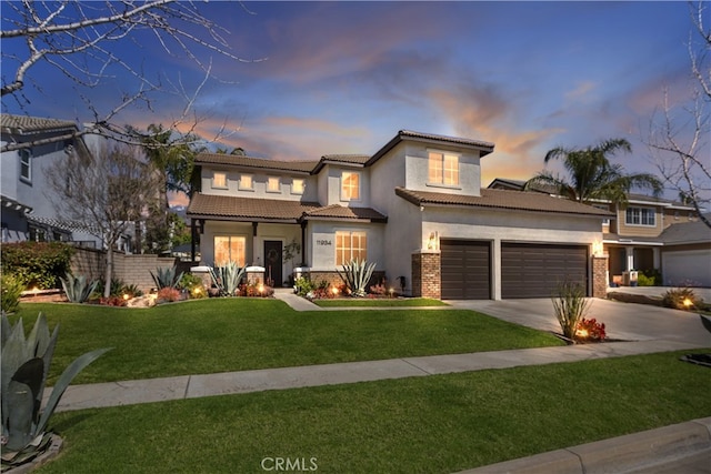 11934 Timber Mountain Ct, Rancho Cucamonga, CA 91739 - mediterranean / spanish home with stucco siding, concrete driveway, a lawn, a tiled roof, and an attached garage