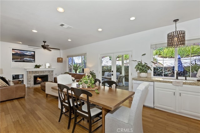 11934 Timber Mountain Ct, Rancho Cucamonga, CA 91739 - dining space featuring a ceiling fan, a brick fireplace, light wood-style flooring, and recessed lighting