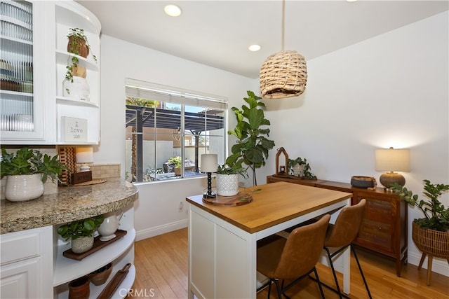 11934 Timber Mountain Ct, Rancho Cucamonga, CA 91739 - kitchen with open shelves, light wood finished floors, white cabinetry, recessed lighting, and a breakfast bar area