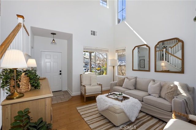 11934 Timber Mountain Ct, Rancho Cucamonga, CA 91739 - living area with light wood-style flooring, a high ceiling, and baseboards