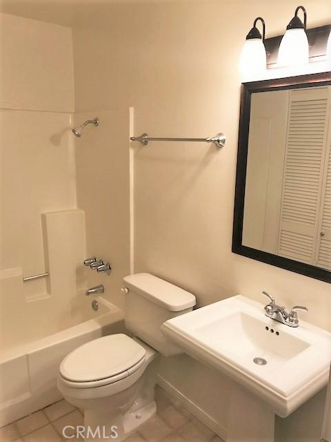 full bath featuring tile patterned floors, toilet, and bathing tub / shower combination
