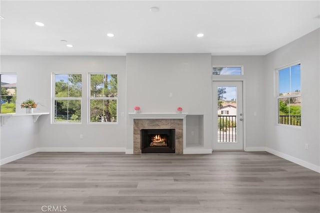 17979 Lost Canyon Rd Unit 104, Canyon Country, CA 91387 - unfurnished living room with healthy amount of natural light, recessed lighting, light wood-type flooring, baseboards, and a fireplace