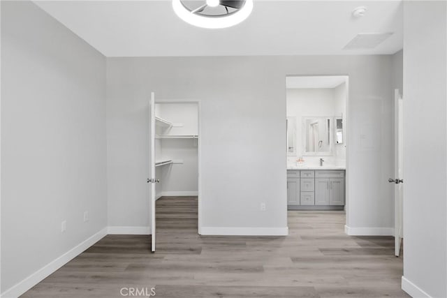 17979 Lost Canyon Rd Unit 104, Canyon Country, CA 91387 - unfurnished bedroom with baseboards, light wood-style flooring, a spacious closet, and a closet