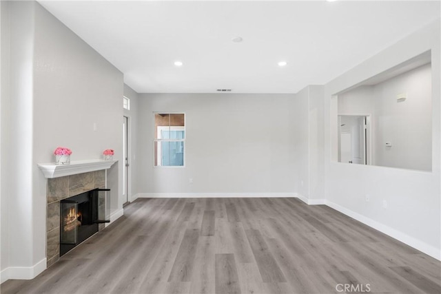 17979 Lost Canyon Rd Unit 104, Canyon Country, CA 91387 - unfurnished living room featuring a tile fireplace, wood finished floors, baseboards, and recessed lighting