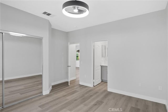 17979 Lost Canyon Rd Unit 104, Canyon Country, CA 91387 - unfurnished bedroom with light wood finished floors, a closet, baseboards, and ensuite bathroom